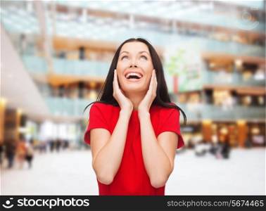 christmas, holidays, valentine&#39;s day, celebration and people concept - smiling woman in red dress over shopping center background