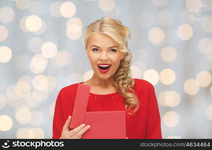 christmas, holidays, valentines day, birthday and people concept - happy excited woman in red dress with gift box over lights background