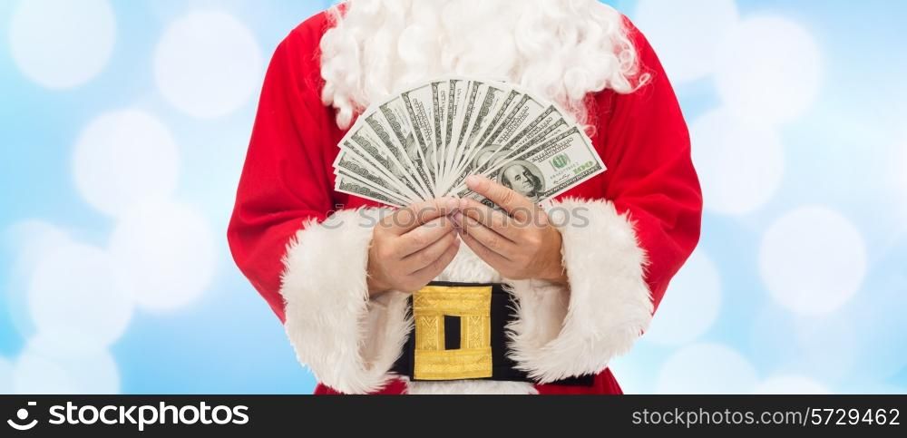 christmas, holidays, winning, currency and people concept - close up of santa claus with dollar money over blue lights background