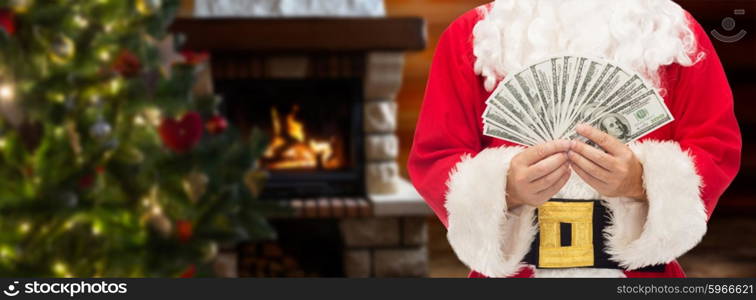 christmas, holidays, winning, currency and people concept - close up of santa claus with dollar money over living room with fireplace and christmas tree background