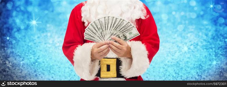christmas, holidays, winning, currency and people concept - close up of santa claus with dollar money over lights or blue glitter background