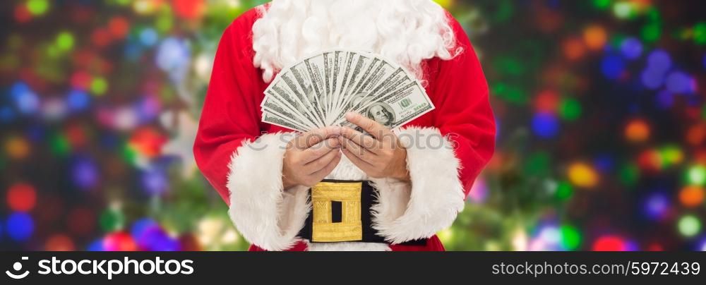 christmas, holidays, winning, currency and people concept - close up of santa claus with dollar money over lights background
