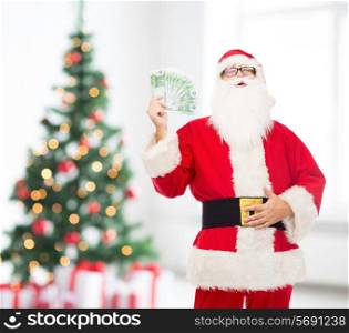 christmas, holidays, winning, currency and people concept - man in costume of santa claus with euro money over living room with tree