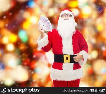 christmas, holidays, winning, currency and people concept - man in costume of santa claus with euro money over red lights background