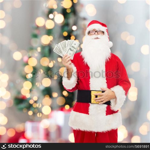 christmas, holidays, winning, currency and people concept - man in costume of santa claus with dollar money over tree lights background