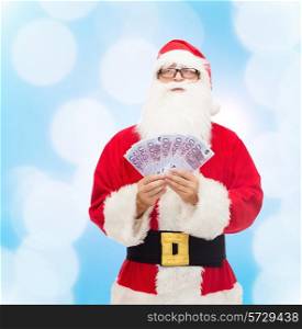 christmas, holidays, winning, currency and people concept - man in costume of santa claus with euro money over blue lights background