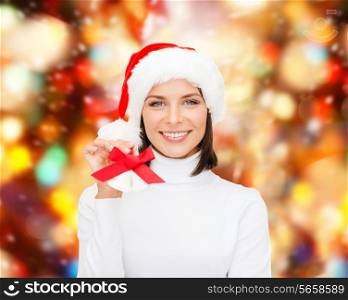 christmas, holidays, winter, happiness and people concept - smiling woman in santa helper hat with jingle bells over red lights background