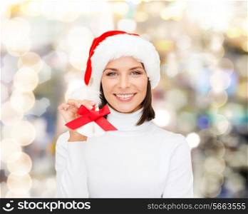 christmas, holidays, winter, happiness and people concept - smiling woman in santa helper hat with jingle bells over lights background