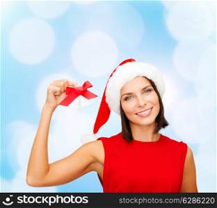 christmas, holidays, winter, happiness and people concept - smiling woman in santa helper hat with jingle bells over blue lights background