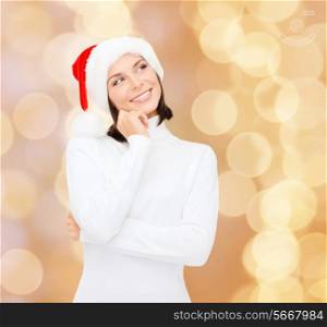christmas, holidays, winter, happiness and people concept - thinking and smiling woman in santa helper hat over beige lights background