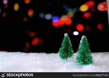 Christmas home decoration with Little handmade gift box in a snow covered miniature evergreen forest and bokeh light for copy space
