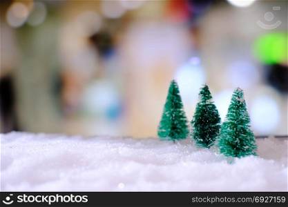 Christmas home decoration with Little handmade gift box in a snow covered miniature evergreen forest and bokeh light for copy space