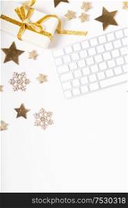 Christmas home office desk with keyboard and christmas gold decorations. Flat lay, top view, copy space over white. Christmas home office desk