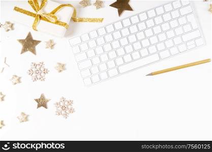 Christmas home office desk with keyboard and christmas gold decorations. Flat lay, top view, copy space.. Christmas home office desk