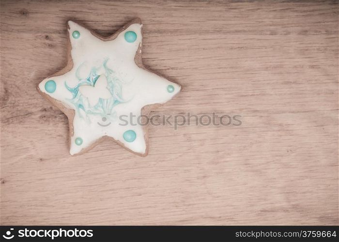 Christmas. Homemade gingerbread cake star with icing and silver decoration on wooden board. Holiday handmade concept.