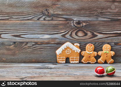 Christmas homemade gingerbread cookies and decoration on wooden background. Gingerbread house and couple - man and woman.