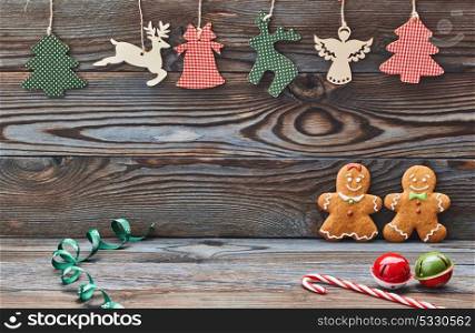 Christmas homemade gingerbread cookies and decoration on wooden background. Gingerbread couple - man and woman.