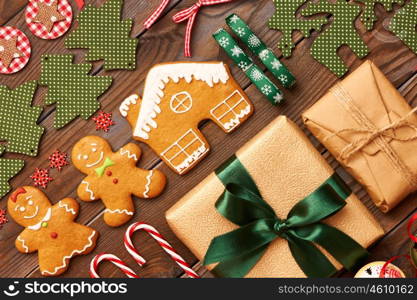 Christmas homemade gingerbread cookies and handmade decoration on wooden background flat lay still life