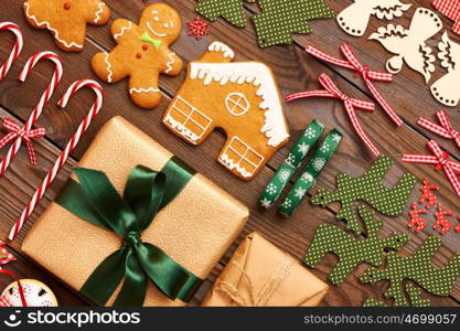 Christmas homemade gingerbread cookies and handmade decoration on wooden background flat lay still life