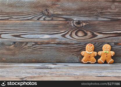 Christmas homemade gingerbread cookies on wooden background. Gingerbread couple - man and woman.
