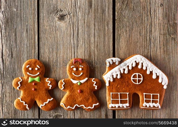 Christmas homemade gingerbread couple and house on wooden table