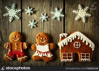 Christmas homemade gingerbread couple and house on wooden table