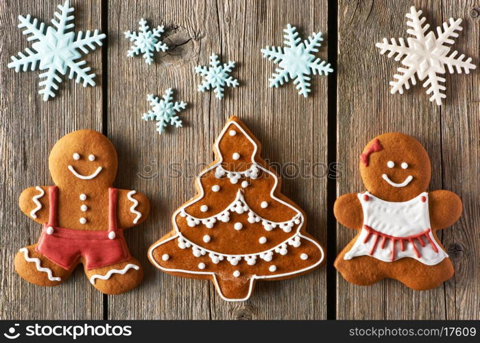 Christmas homemade gingerbread couple and tree on wooden table