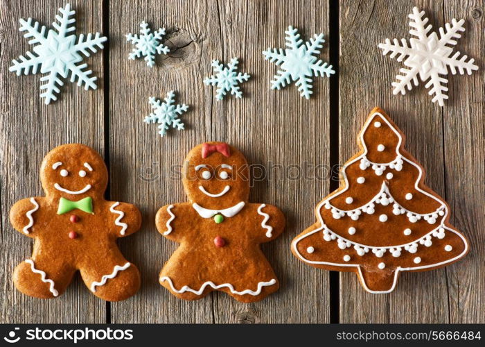 Christmas homemade gingerbread couple and tree on wooden table