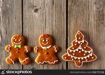 Christmas homemade gingerbread couple and tree on wooden table