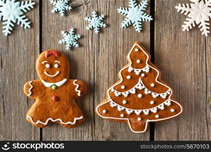 Christmas homemade gingerbread girl and tree on wooden table