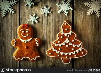 Christmas homemade gingerbread girl and tree on wooden table
