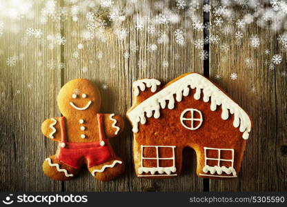 Christmas homemade gingerbread man and house on wooden table