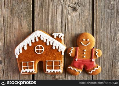 Christmas homemade gingerbread man and house on wooden table