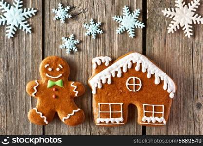 Christmas homemade gingerbread man and house on wooden table