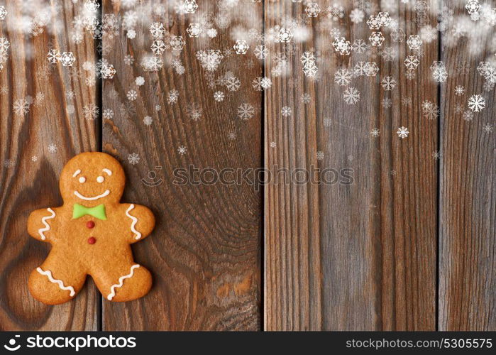 Christmas homemade gingerbread man cookie on wooden background