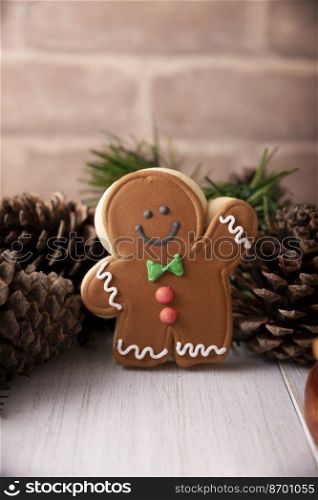 Christmas Homemade gingerbread man cookie waiving a hand saying hello, traditionally made at wintertime and the holidays.