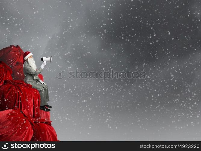 Christmas is coming!. Businessman in Santa costume shouting in megaphone