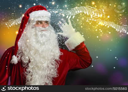 Christmas is coming. Santa Claus enjoying sound of distant music