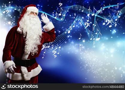 Christmas is coming. Santa Claus enjoying the sound of music