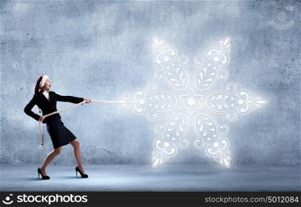 Christmas is coming. Santa woman pulling white snowflake on rope