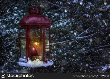 Christmas lamp with glass and candle inside in the night to pine tree. Snowing around the lamp. Snowflakes flying in the night.