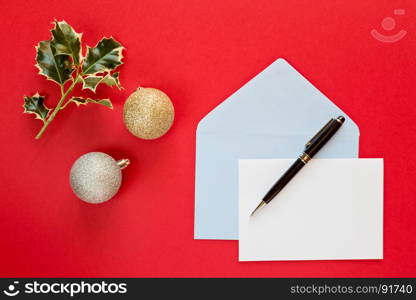Christmas letter and pen over a red background with decorations. Christmas letter over a red background
