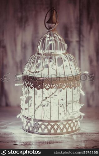 Christmas light decoration in a white bird cage.. Christmas light in a cage