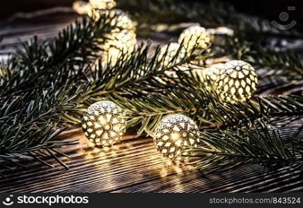 christmas lights and fir branche on wooden background. vintage garland. christmas lights and fir branches on wooden background. vintage garland and bokeh.