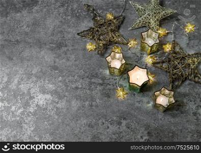 Christmas lights decoration. Candles and golden stars on dark background stars