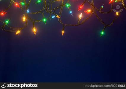 Christmas lights on blue background with copy space