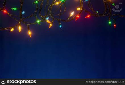Christmas lights on blue background with copy space