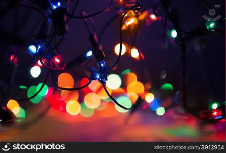 Christmas lights on dark background. Decorative garland. Tinted photo