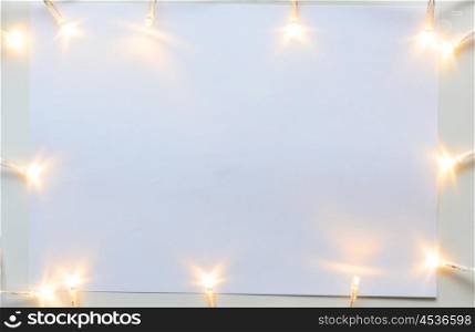 Christmas lights on gray table, view from above