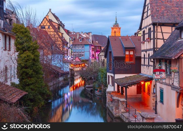 Christmas Little Venice in Colmar, Alsace, France. Traditional Alsatian half-timbered houses, church and river Lauch in Petite Venise or little Venice, old town of Colmar, decorated and illuminated at christmas time, Alsace, France